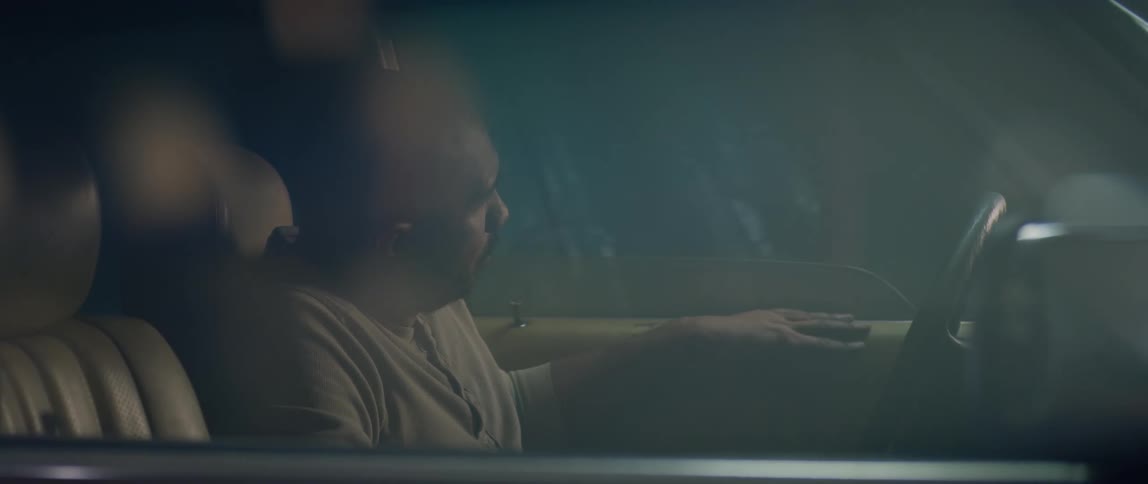 A man looks out the window of his parked car