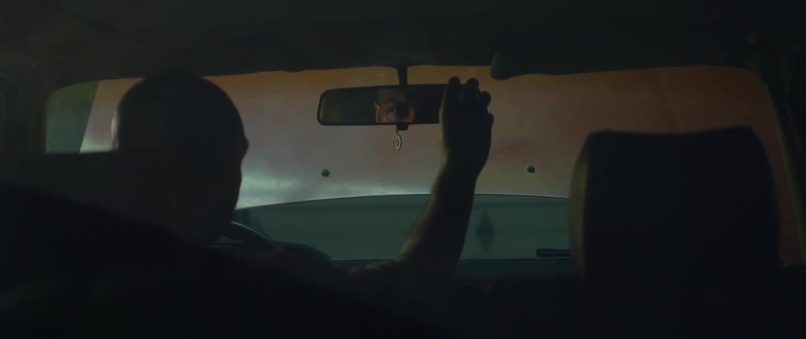 A man adjusts the rear view mirror in the car