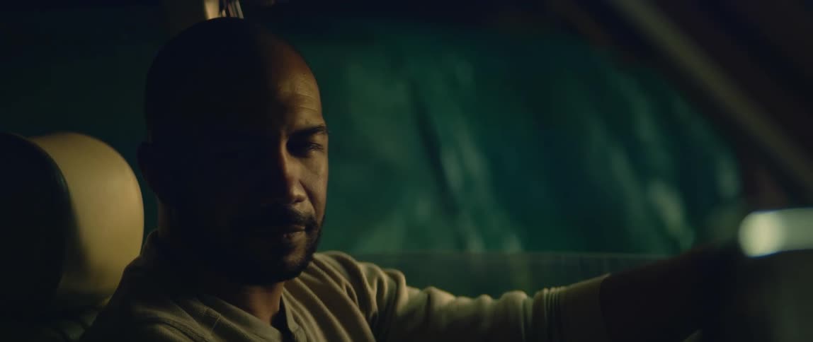 A man sits in his car and looks sad as he thinks