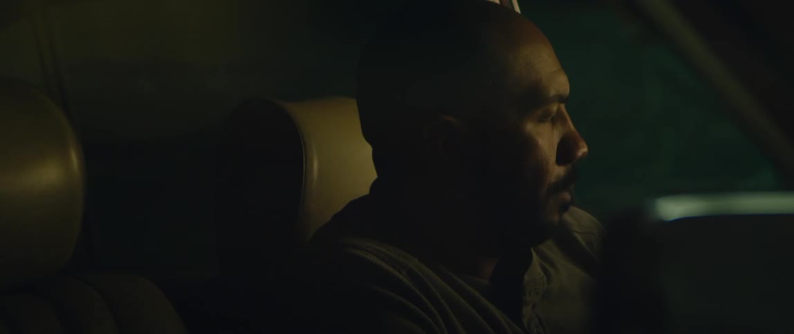 A man looks worried as he sits in his car at night