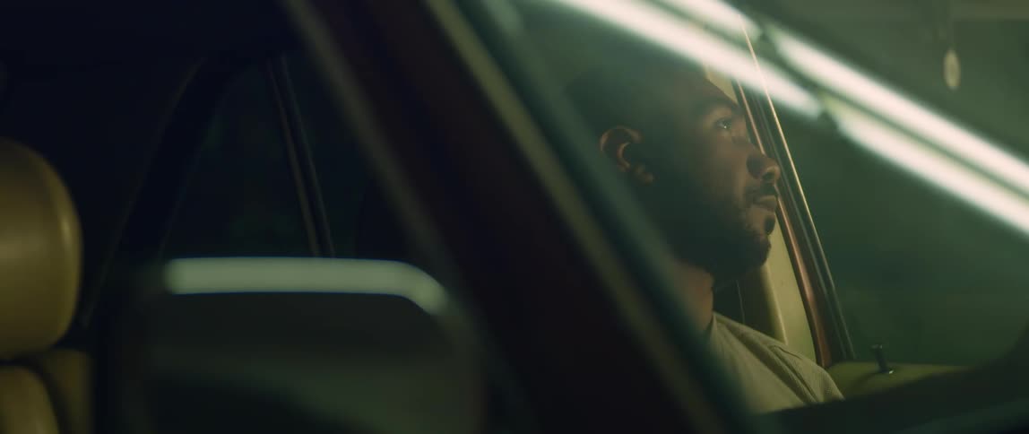 A man leans his head back and closes his eyes as he sits in a car