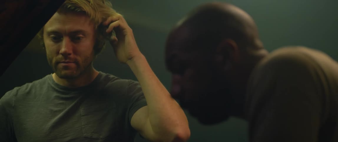 Two men appear frustrated while looking under the hood of a car