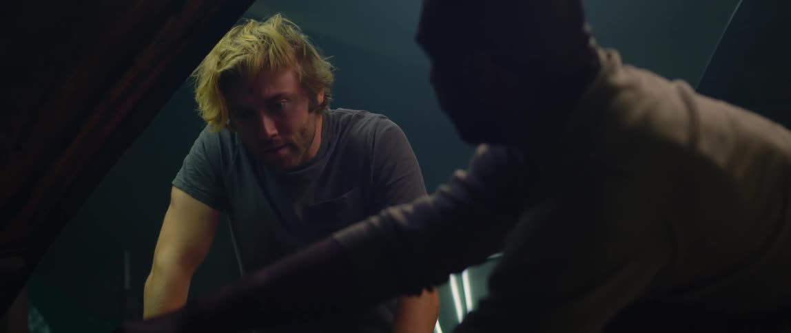 Two men work under the hood of a vehicle
