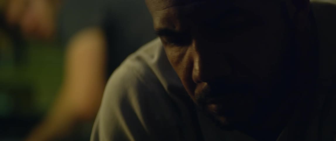 A man is leaning over looking tired and another man is looking at him over his shoulder