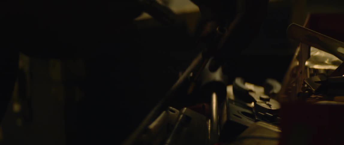 A person picking up tools in a workshop