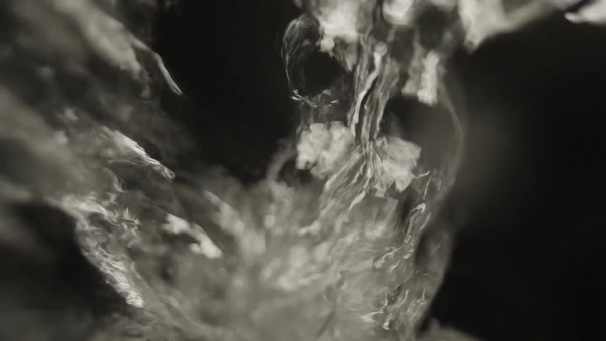 Water reflects light as it is pouring and rushing downward