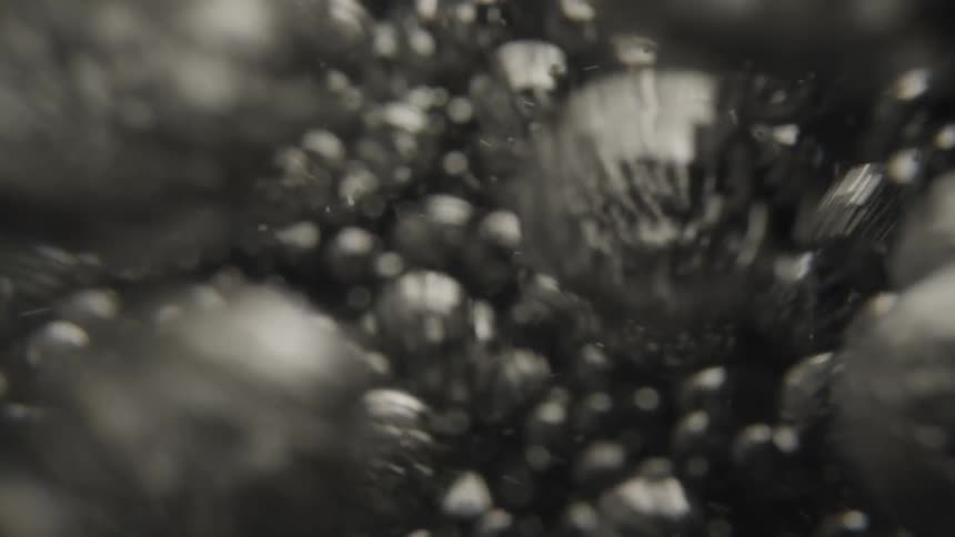 Bubbles in liquid rising and surging shimmering and reflecting light