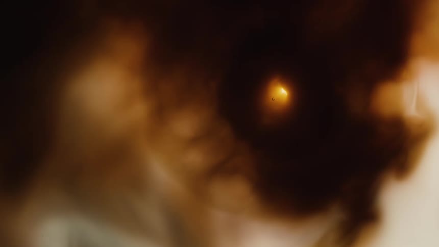 Visual effect of a moving cloud of dark ocher liquid ink flowing in slow waves