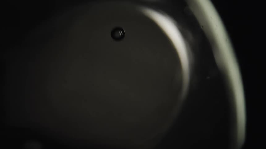 Abstract footage of an object dropping in liquid with bubbles