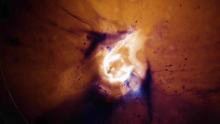 Smoke and particles floating away from a white hot center burning mass