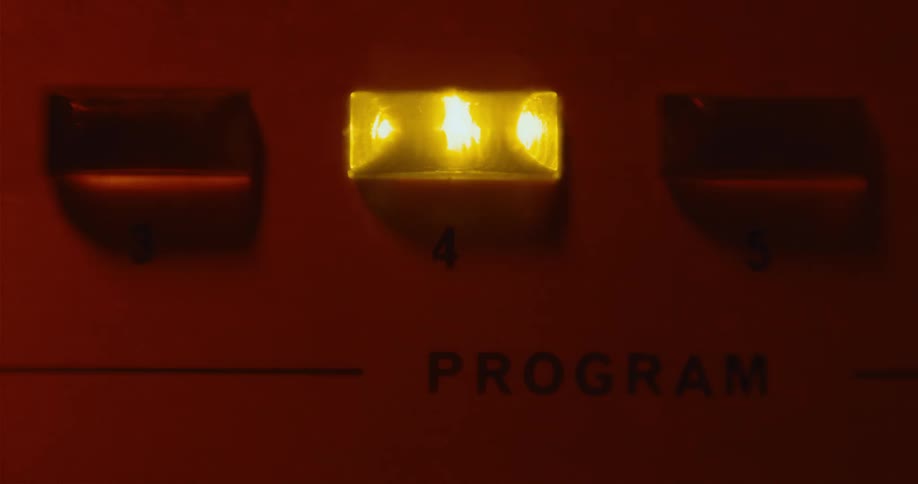 A button on electronic equipment comes on glowing yellow then off