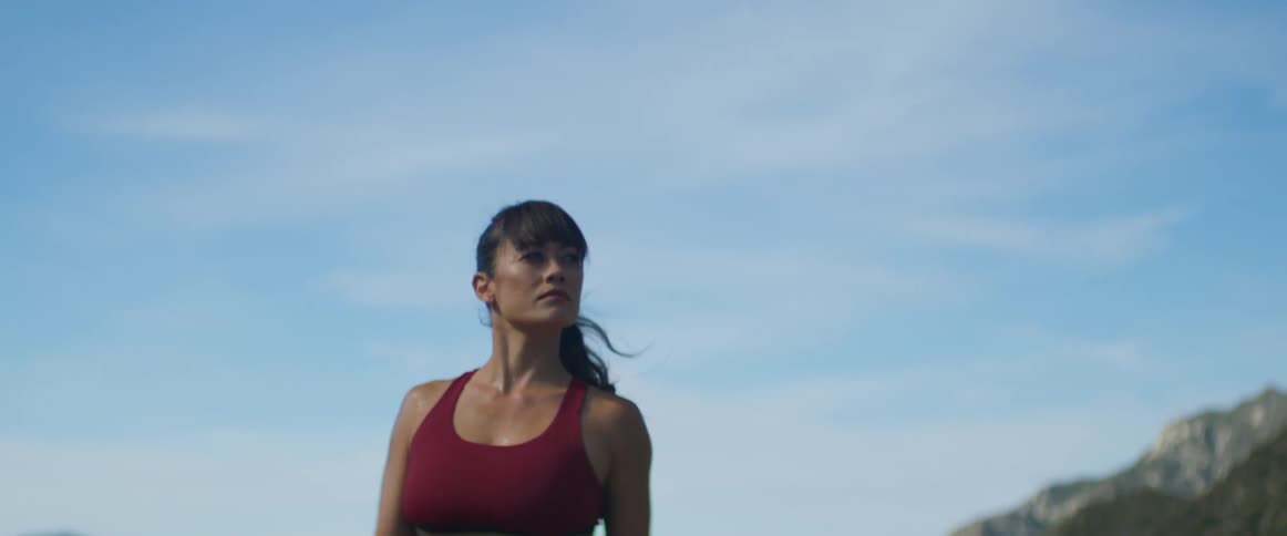A woman poses in sports wear in a canyon