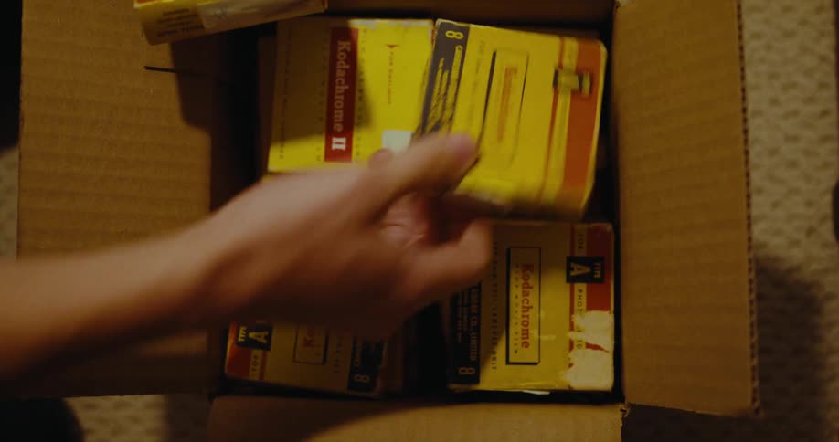 Someone opens a box filled with kodachrome film and they take out three packs