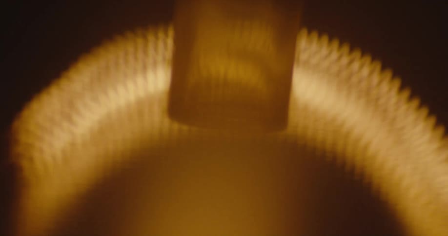 An arched shaped light stretches across a bright yellow and orange light