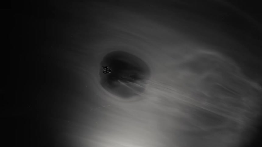 A wave of smoke moves across the darkness and a hole opens in the smoke and grows