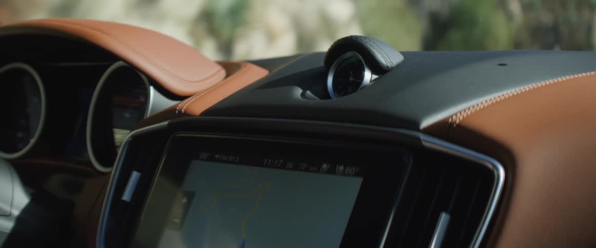 A driver taps on the gps screen on his dashboard selecting a route while driving