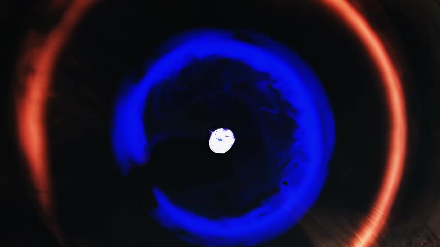 Rings of different colored paint spread outward from a central point