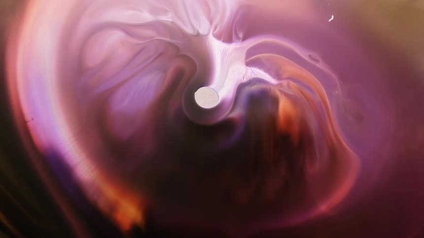 An illuminated pink liquid like substance is flowing from the center of a bubble and growing outward