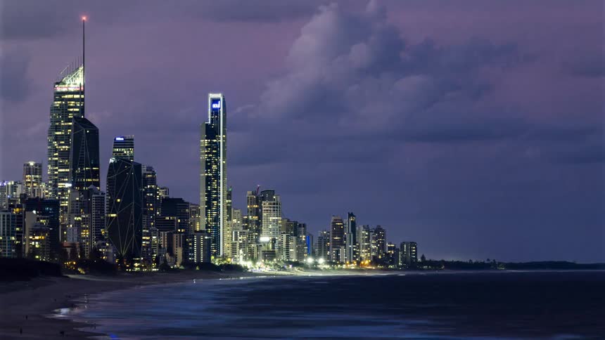 Water gently laps at a beach on the shore of a large city