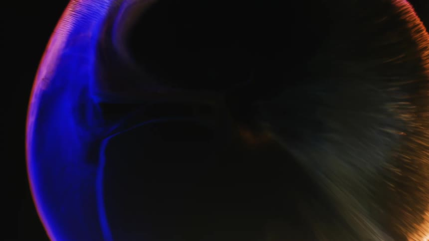 An organic sphere glows as it grows in the darkness