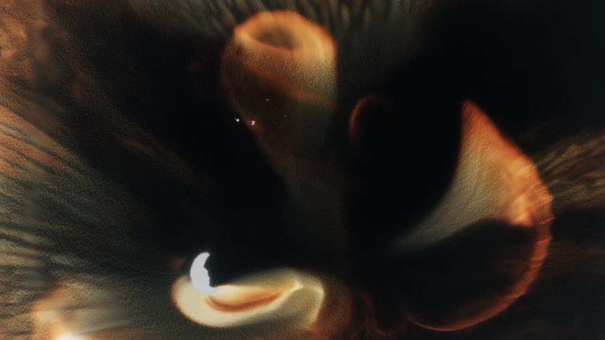 Visual effect of a moving cloud of dark ocher liquid ink flowing in slow waves and streaks