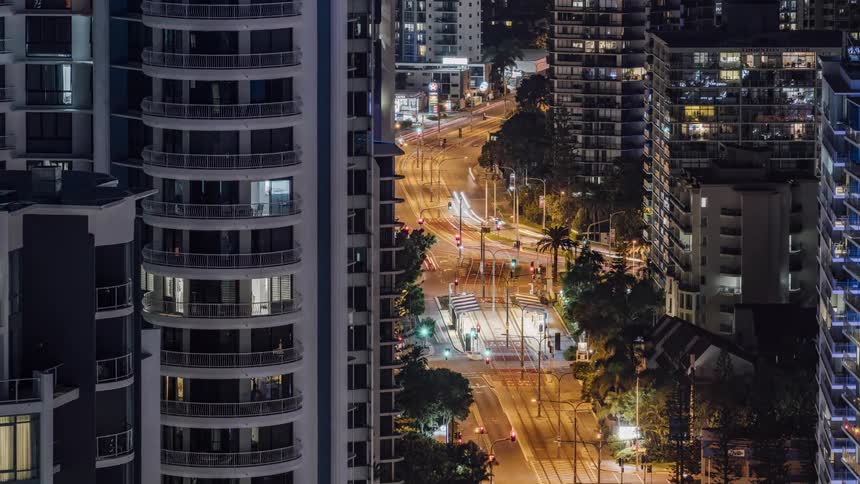 City condominiums next to illuminated highways with vehicles driving at night