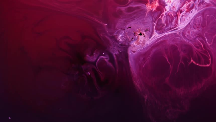 A bright pink glowing jelly like substance is moving and expanding as if it is alive