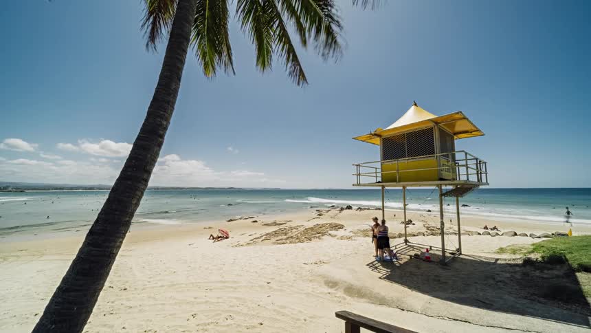 Ocean waves break against the white sand beach