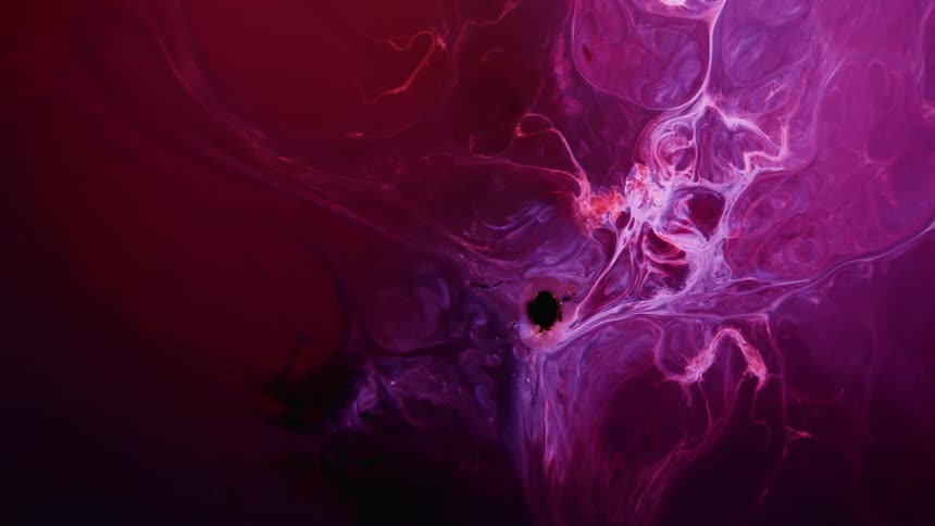 A pink paintlike liquid mixes with lighter colored ones to make a surreal and artistic scene