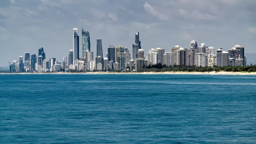 Ocean waves off the coast of a metropolis on a cloudy day