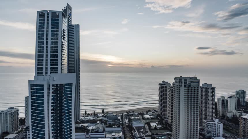 The sun rises over the coast of a metropolis