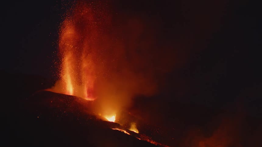 Lava erupts from a volcano at night