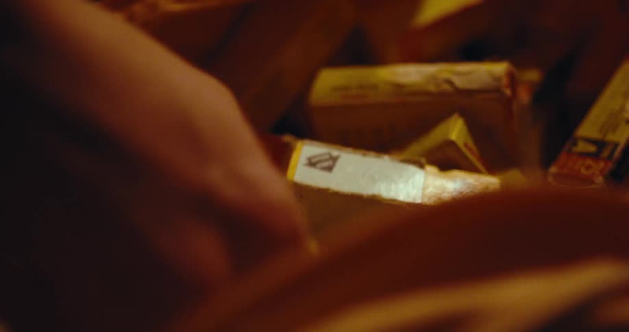 A person unzips a bag and takes a box out