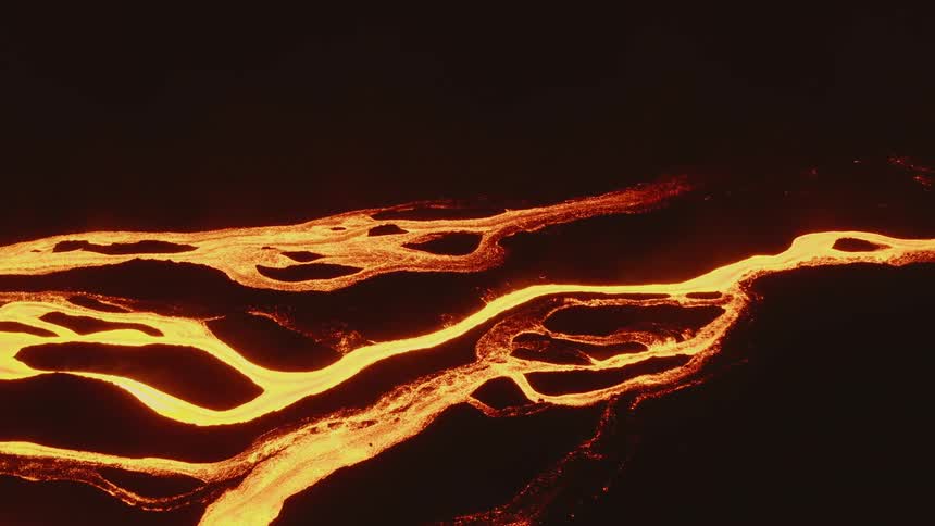 Streams of lava glowing bright orange at night