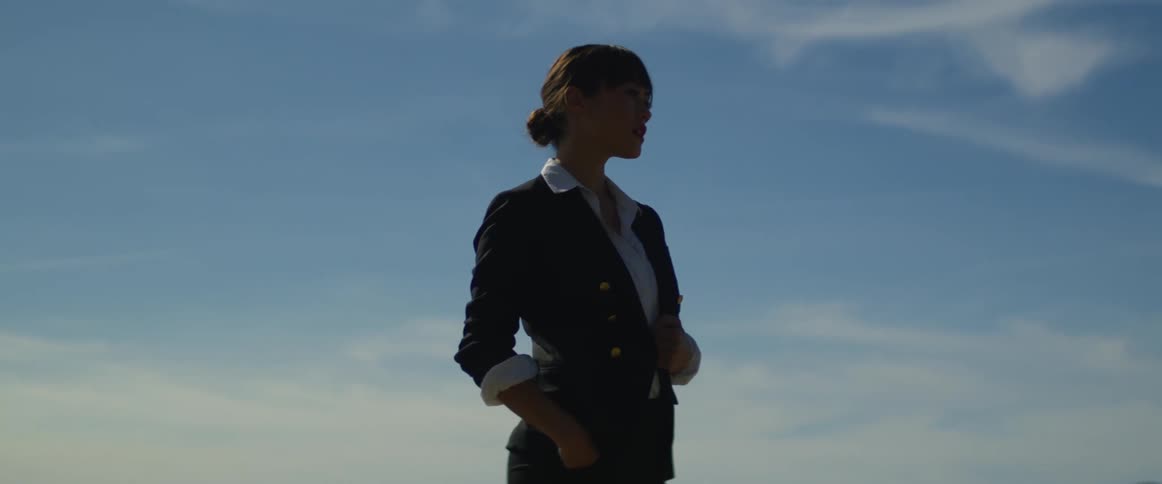 A woman dressed in a suit is standing outside