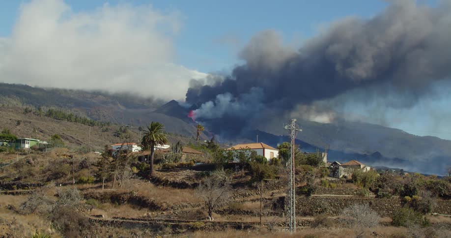 Smoke rises from a volcano erupting near a rural community