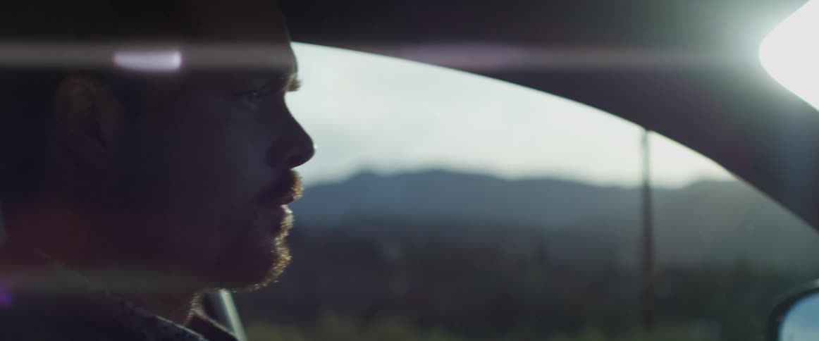 A man drives a vehicle through the countryside during the day