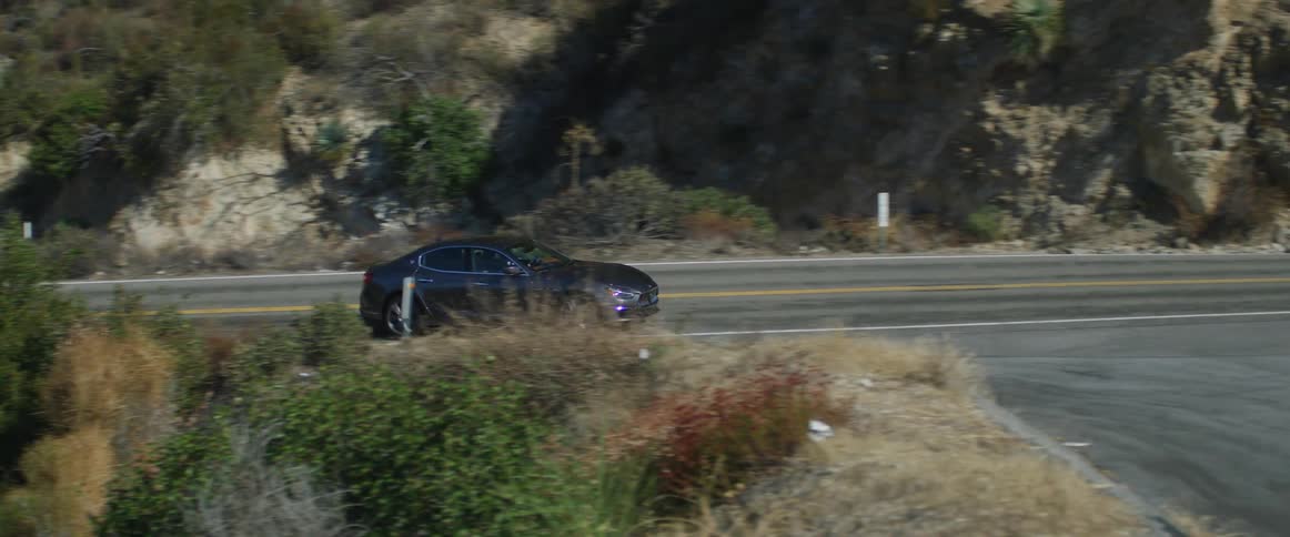 A car is driving on a rural road in the spring time