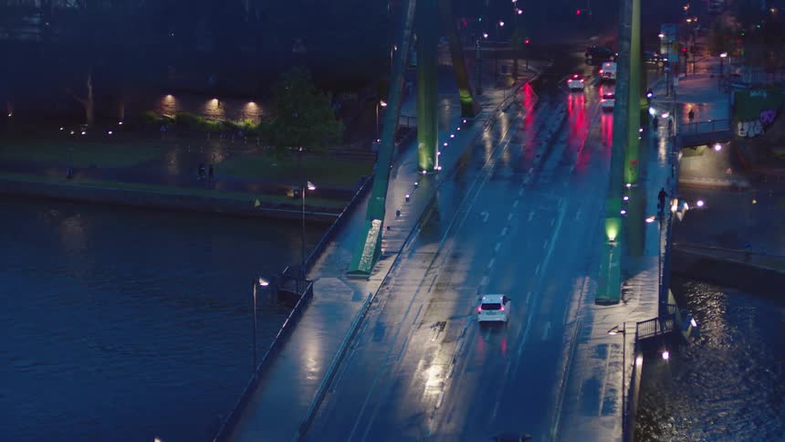 Cars are driving towards a downtown city at night