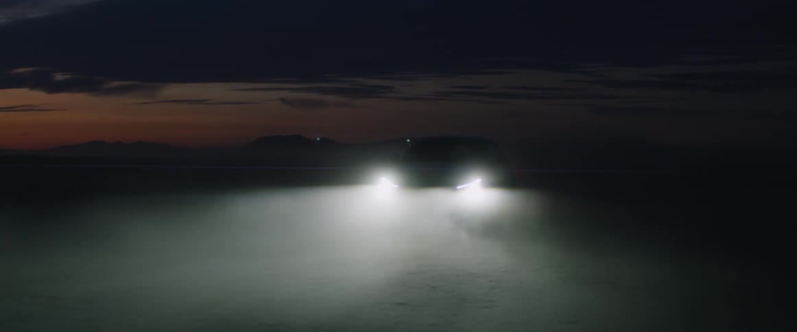 Car headlights glow at dusk creating foggy light