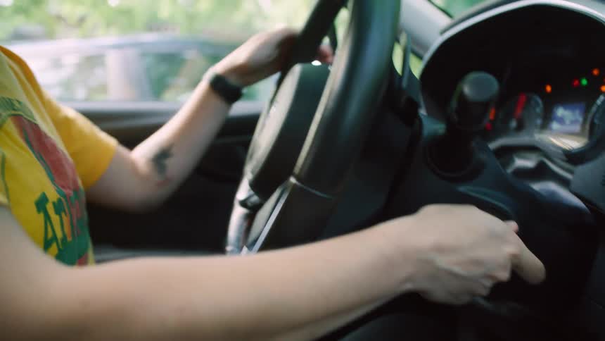 A woman backs her vehicle out of a parking lot