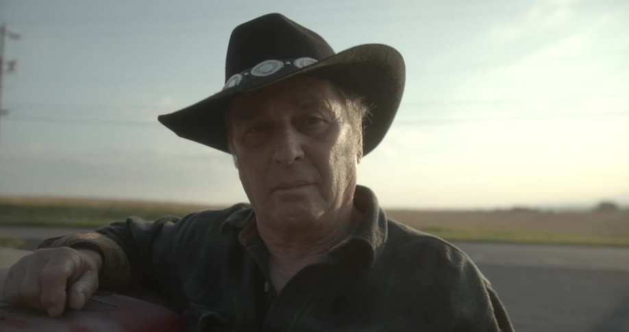A man leans on his car