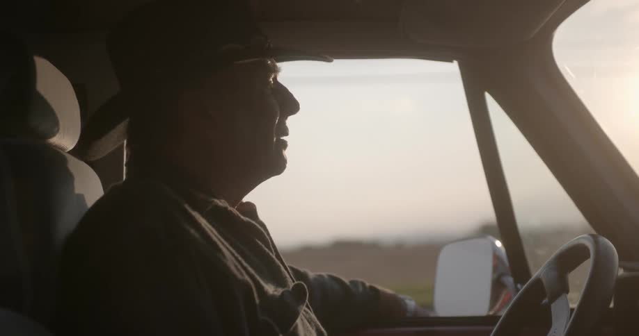 A man sighs while sitting in his truck