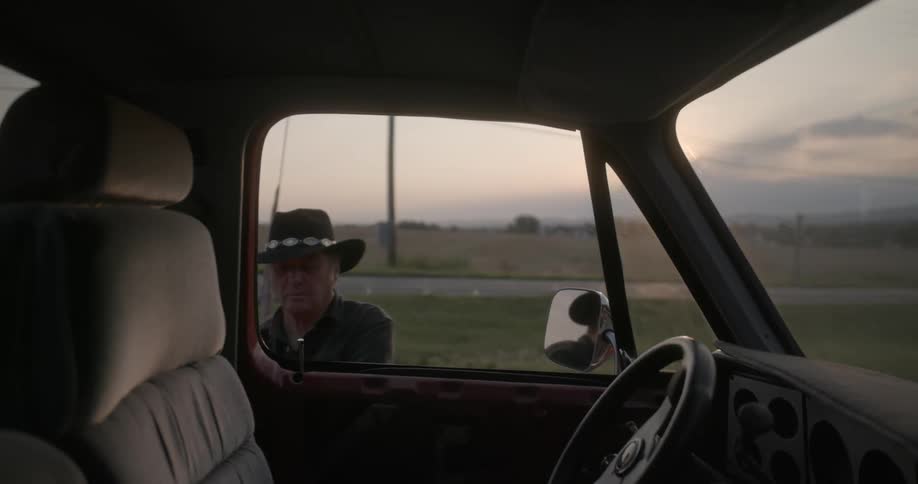Man walks across field and gets into truck