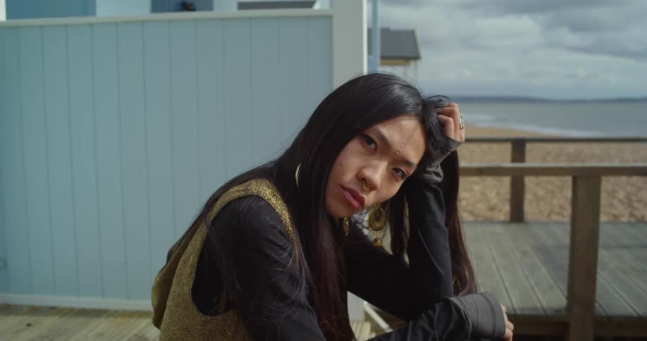 Portrait of a woman sitting by a beach hut