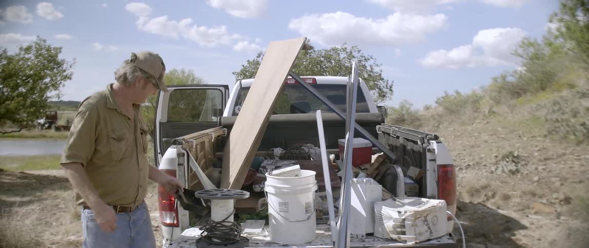 A man working out of the back of his pickup truck