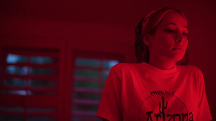 A young woman is inside of a room indoors at night time