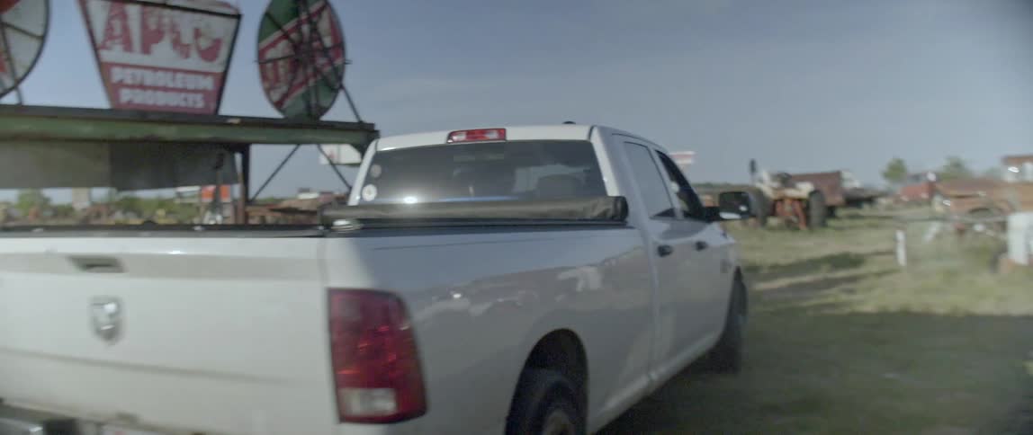 A white truck drives through a rural area