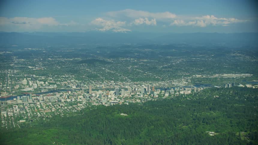 White puffy clouds high above Portland Oregon on a warm summer day showing the vastness of the city and neighborhoods
