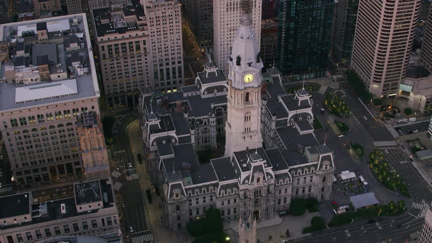 A clock tower sits in the center of a block of buildings